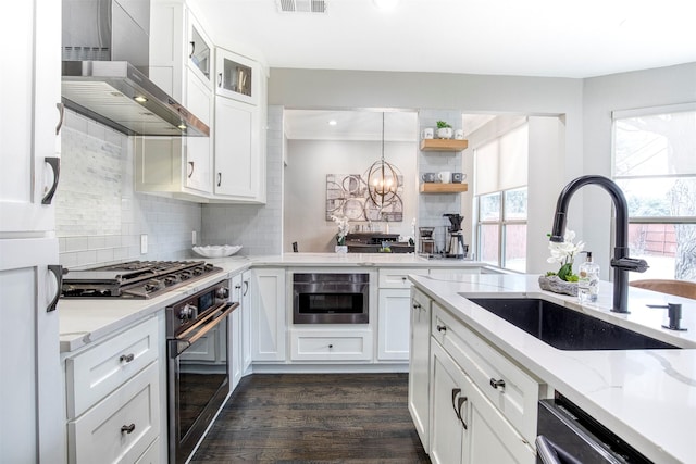 kitchen with glass insert cabinets, white cabinetry, a sink, and appliances with stainless steel finishes