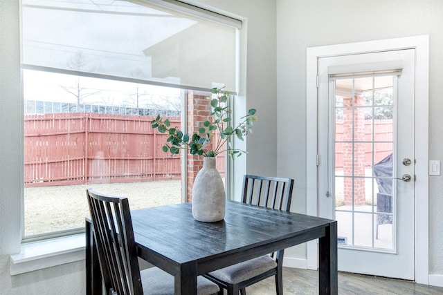 dining area featuring a healthy amount of sunlight, baseboards, and wood finished floors