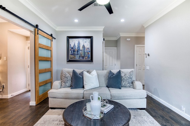 living area with a barn door, visible vents, baseboards, dark wood-style floors, and ornamental molding