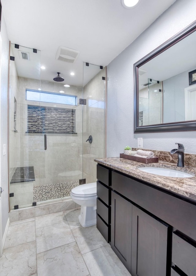 full bath featuring a stall shower, visible vents, toilet, marble finish floor, and vanity