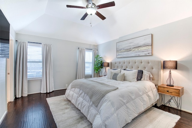 bedroom with dark wood finished floors, lofted ceiling, a raised ceiling, ceiling fan, and baseboards