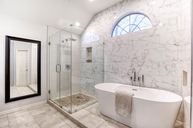 bathroom featuring lofted ceiling, a freestanding tub, and a shower stall