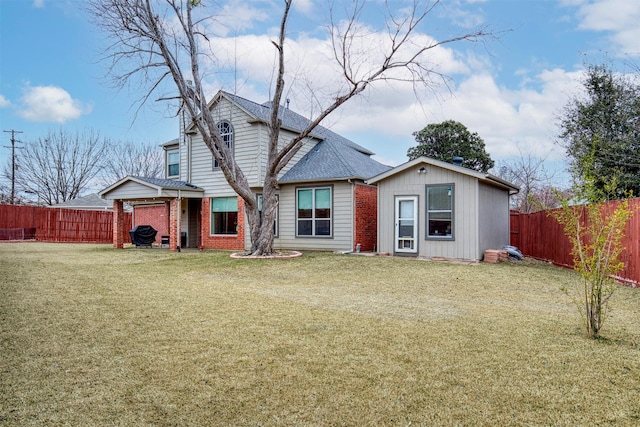 back of house with a yard, brick siding, a shingled roof, and a fenced backyard