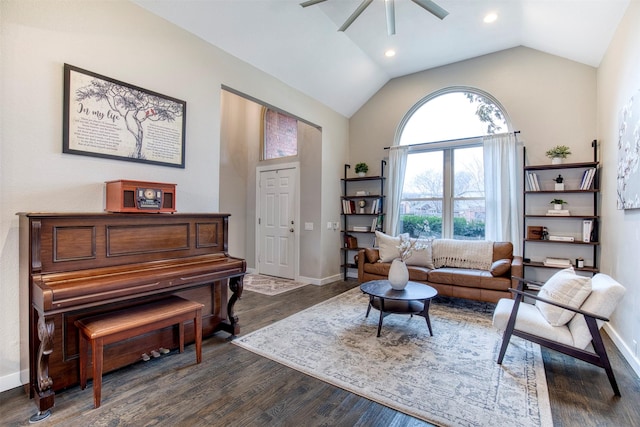 sitting room with dark wood-style flooring, vaulted ceiling, baseboards, and ceiling fan