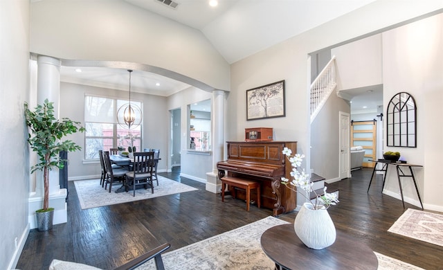 interior space with dark wood-type flooring, a chandelier, decorative columns, and baseboards