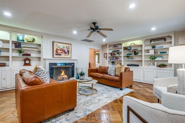 living room with visible vents, built in features, ceiling fan, a fireplace, and recessed lighting