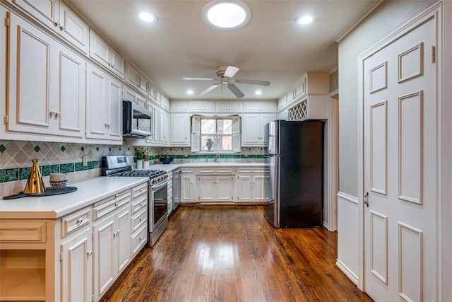 kitchen featuring ceiling fan, appliances with stainless steel finishes, dark wood-type flooring, light countertops, and white cabinetry