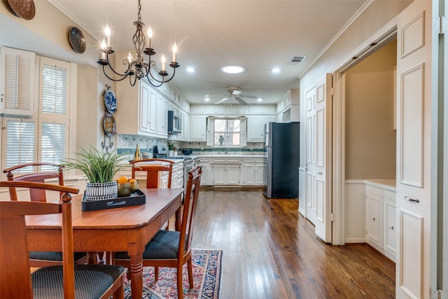 kitchen with stainless steel appliances, visible vents, white cabinets, light countertops, and pendant lighting