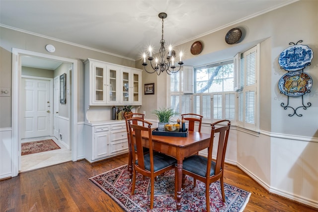 dining area featuring dark wood-style floors, a notable chandelier, and crown molding