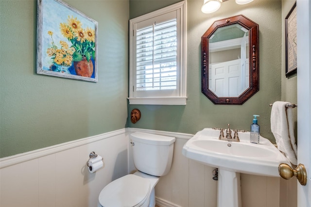 half bath with wainscoting and toilet