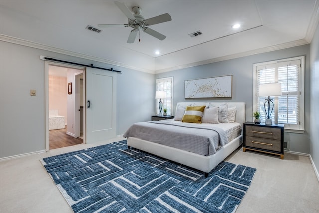 carpeted bedroom featuring visible vents, crown molding, baseboards, and a barn door