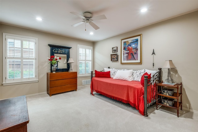 bedroom featuring multiple windows, visible vents, ornamental molding, and light colored carpet