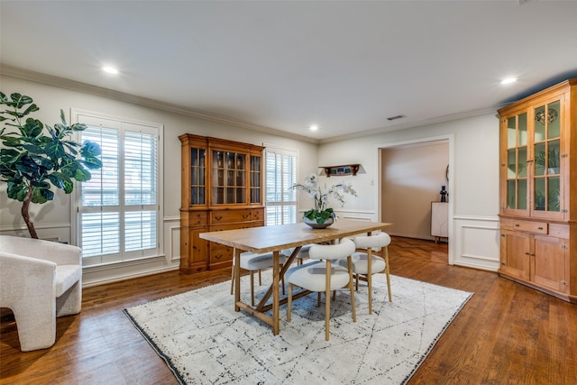 dining room with recessed lighting, a wainscoted wall, a decorative wall, wood finished floors, and ornamental molding