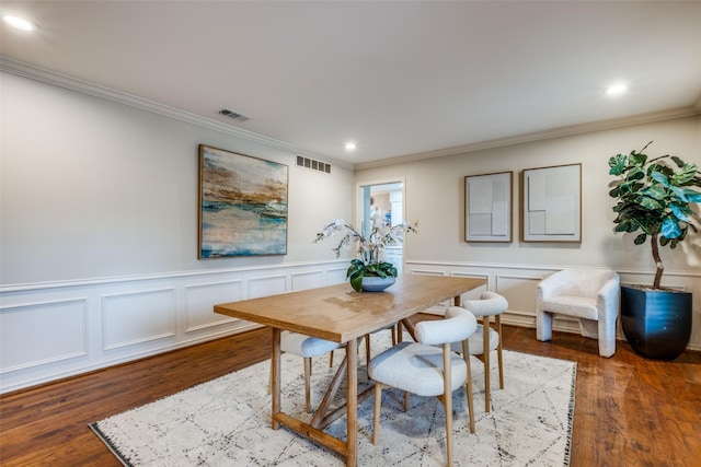 dining area featuring visible vents, wood finished floors, and ornamental molding