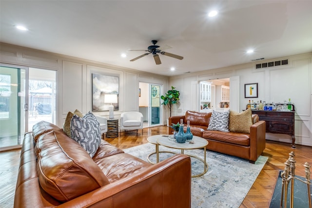 living area featuring recessed lighting, visible vents, and a decorative wall