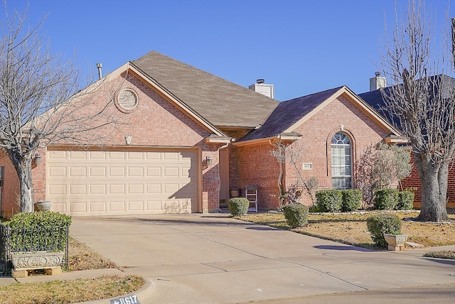 view of front of house with an attached garage, brick siding, driveway, roof with shingles, and a chimney