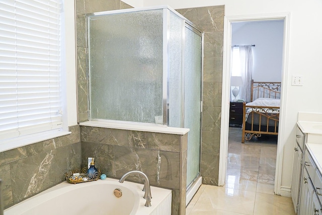 ensuite bathroom featuring ensuite bathroom, vanity, a healthy amount of sunlight, a bath, and a stall shower