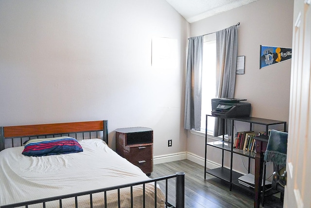 bedroom featuring lofted ceiling, dark wood-style floors, and baseboards