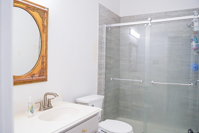 bathroom featuring vanity, toilet, and a shower stall