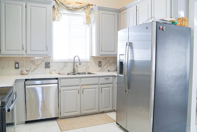 kitchen with gray cabinets, stainless steel appliances, a sink, and light countertops