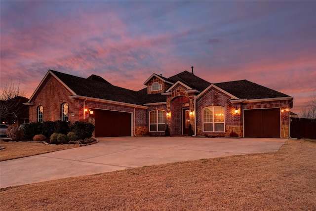 view of front of property featuring a garage, driveway, and brick siding