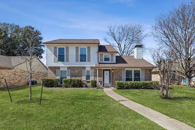 view of front of home featuring brick siding, a chimney, a front lawn, and roof with shingles