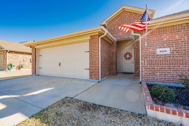 view of front of property with a garage, driveway, and brick siding