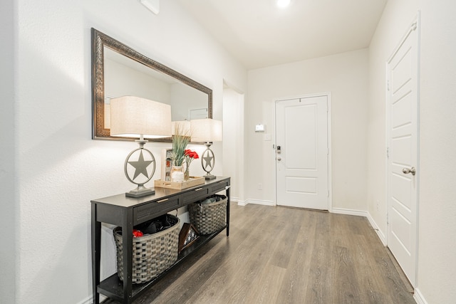 foyer featuring baseboards and wood finished floors