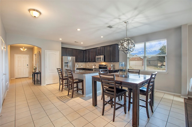 dining area featuring arched walkways, light tile patterned floors, a chandelier, recessed lighting, and visible vents