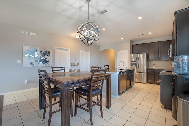 dining area featuring arched walkways, a chandelier, light tile patterned flooring, recessed lighting, and visible vents