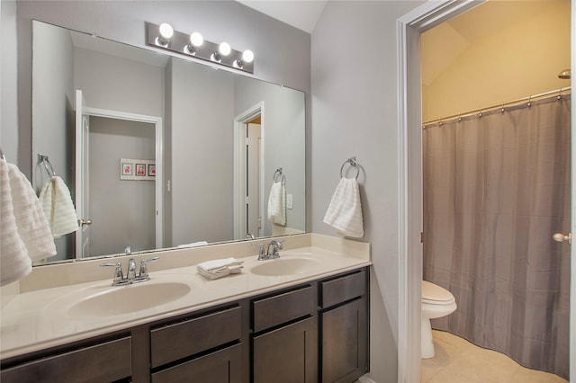 bathroom featuring tile patterned floors, a sink, toilet, and double vanity