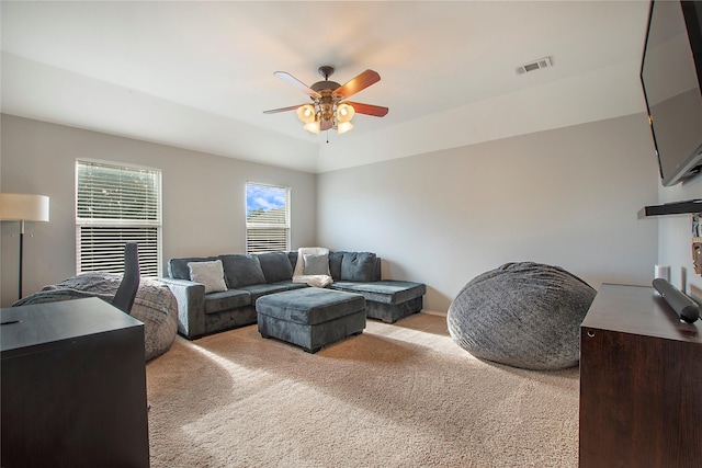 living room featuring light carpet, visible vents, and a ceiling fan