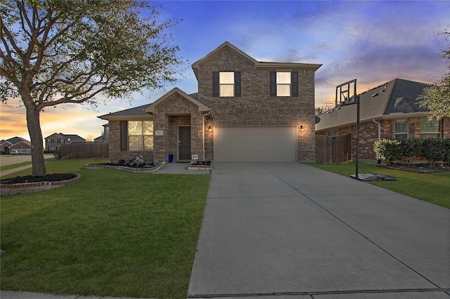traditional home featuring a garage, brick siding, fence, a yard, and concrete driveway