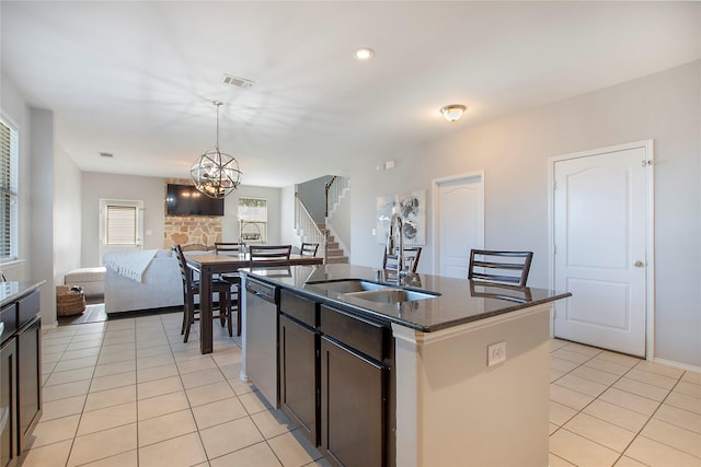 kitchen featuring dishwasher, an island with sink, open floor plan, pendant lighting, and a sink