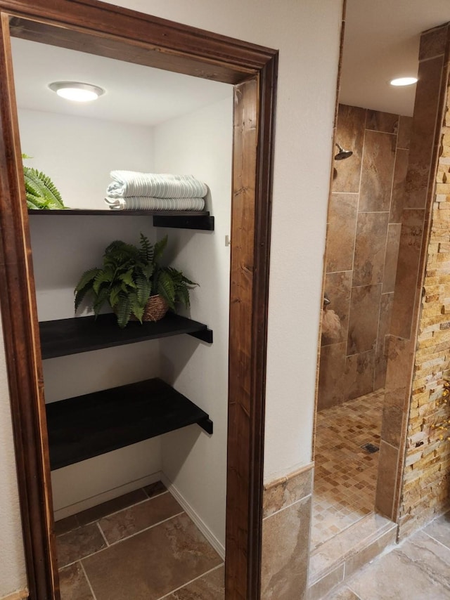 bathroom with a walk in shower and baseboards