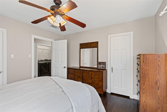 bedroom featuring dark wood-style floors, a textured ceiling, visible vents, and a ceiling fan