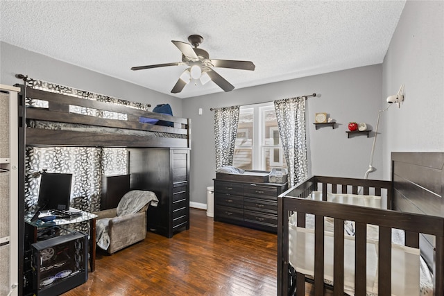 bedroom featuring baseboards, a textured ceiling, a ceiling fan, and dark wood-style flooring