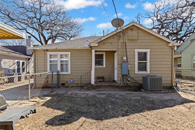 rear view of house featuring roof with shingles, fence, and central air condition unit