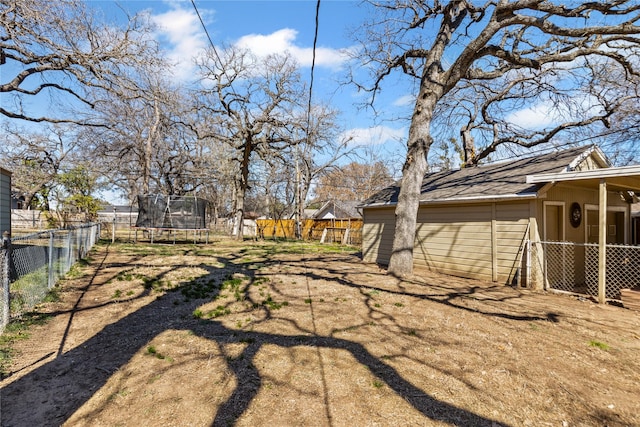 view of yard with a trampoline and a fenced backyard