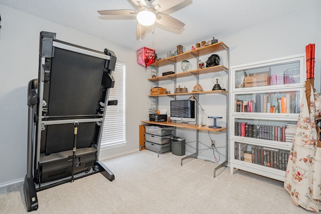 office space with light carpet, a textured ceiling, a ceiling fan, and baseboards