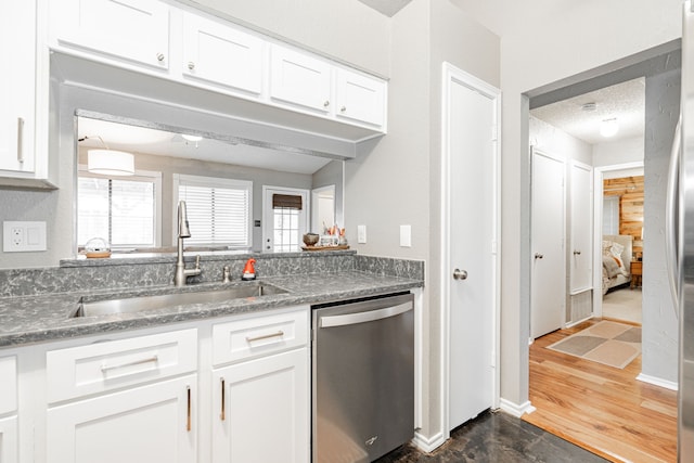 kitchen featuring a sink, white cabinetry, baseboards, appliances with stainless steel finishes, and dark wood finished floors