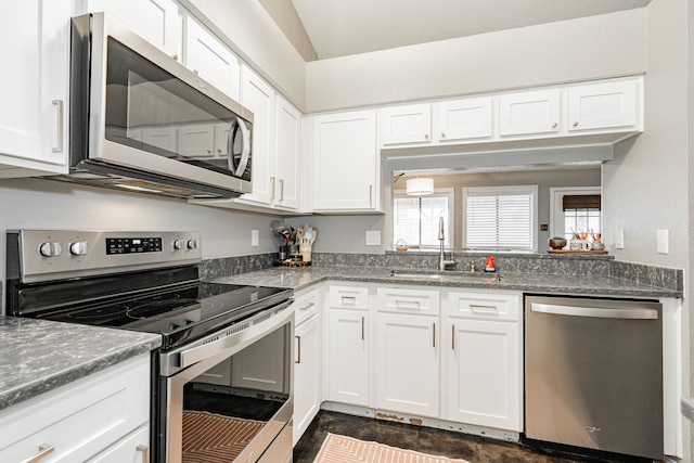 kitchen featuring appliances with stainless steel finishes, a sink, and white cabinets