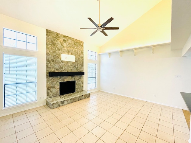 unfurnished living room featuring ceiling fan, high vaulted ceiling, a stone fireplace, and light tile patterned floors