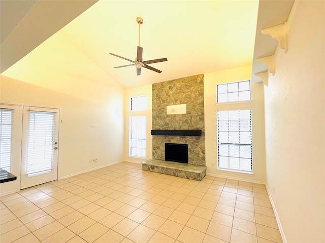 unfurnished living room featuring a fireplace, light tile patterned floors, ceiling fan, high vaulted ceiling, and baseboards