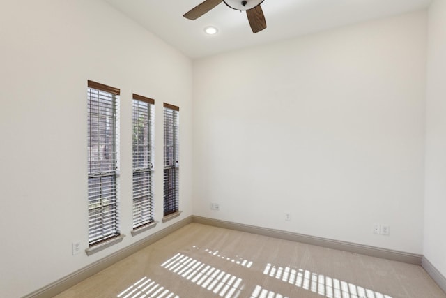 unfurnished room featuring light carpet, ceiling fan, and baseboards