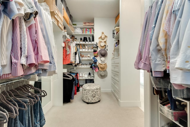 walk in closet featuring light carpet