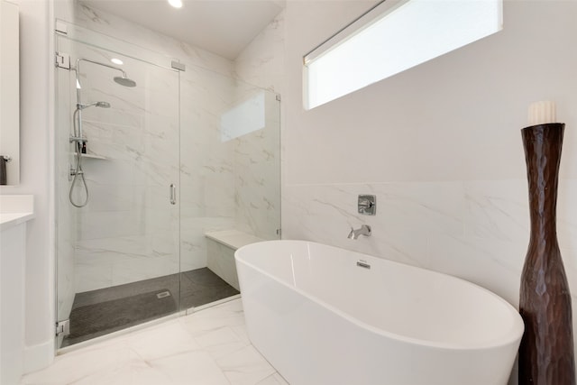 bathroom with a freestanding tub, recessed lighting, tile walls, marble finish floor, and a marble finish shower