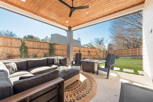 view of patio / terrace with ceiling fan, a fenced backyard, and an outdoor living space with a fire pit