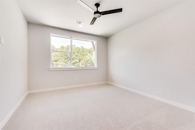 carpeted empty room with baseboards, visible vents, and ceiling fan