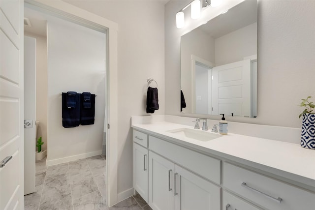 bathroom featuring marble finish floor, vanity, and baseboards